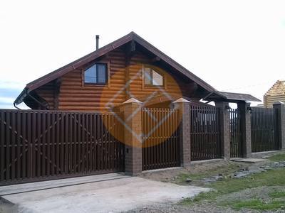 Забор из евроштакетника на фундаменте для участка с домом из бруса